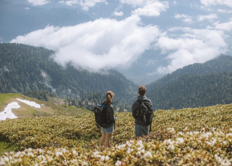 Randonneur équipé pour une sortie estivale en montagne, vêtements légers et sac à dos
