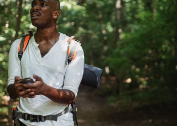 Randonneur en forêt consultant son smartphone pendant une sortie