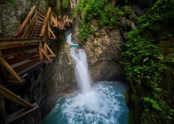 Passerelle dans une gorge fraîche avec cascade en été