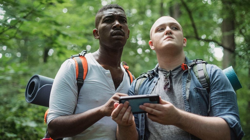 Deux randonneurs consultant un smartphone pour s’orienter en forêt