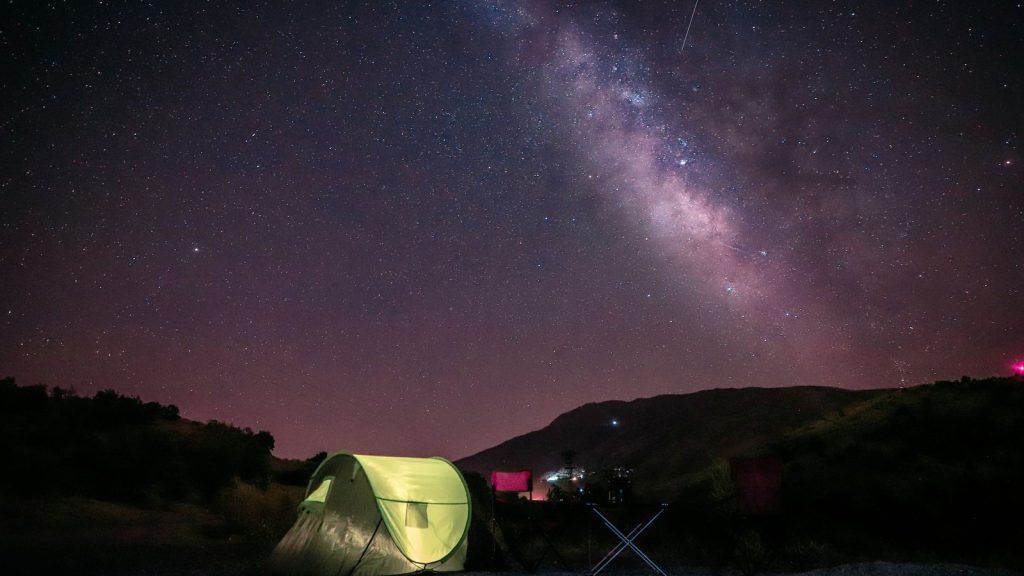 Tente sous une Voie lactée en montagne, ambiance bivouac nocturne