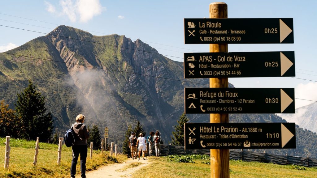 Randonneurs sur un sentier de montagne avec panneau directionnel