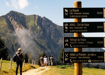 Randonneurs sur un sentier de montagne avec panneau directionnel
