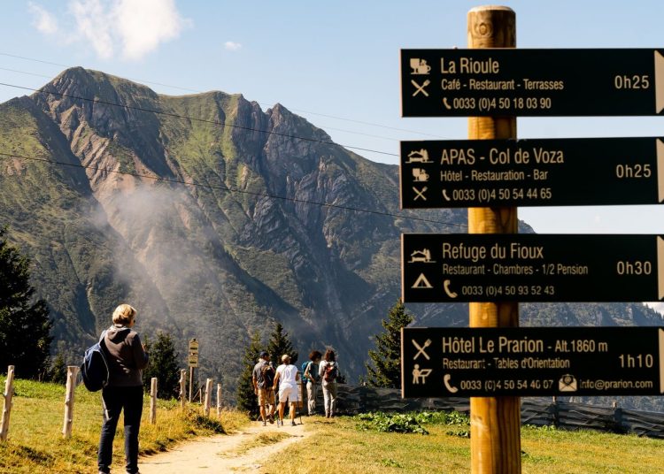 Randonneurs sur un sentier de montagne avec panneau directionnel