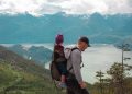 Parent portant un enfant dans un porte-bébé sur un sentier de montagne