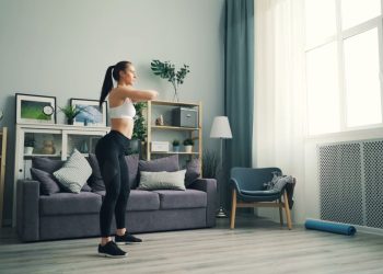 Femme réalisant un exercice debout dans son salon