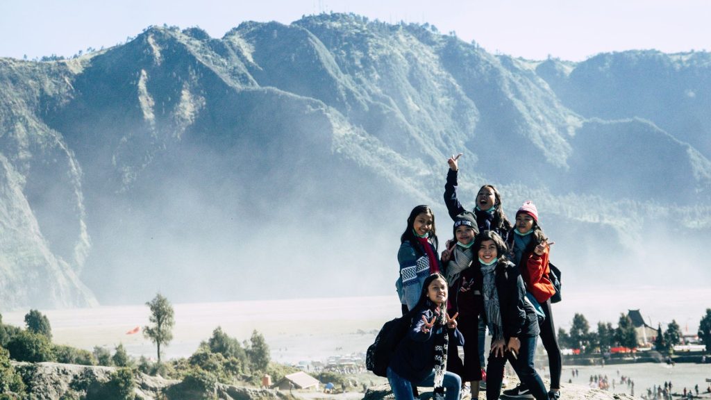 Groupe de randonneuses en veste de montagne posant sur une crête dans la brume