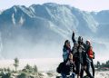 Groupe de randonneuses en veste de montagne posant sur une crête dans la brume