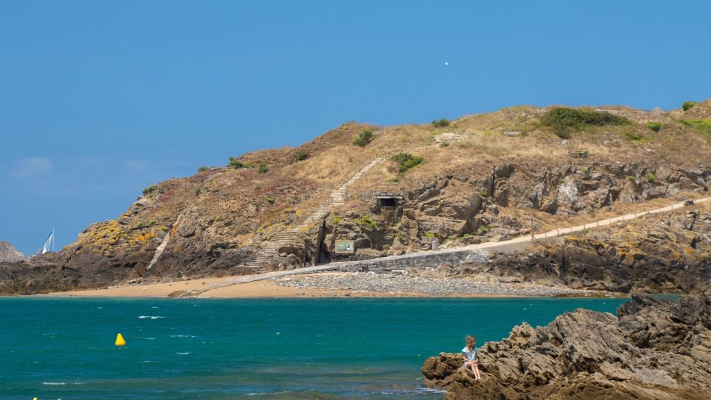 Sentier côtier breton longeant des falaises au-dessus d’une mer turquoise