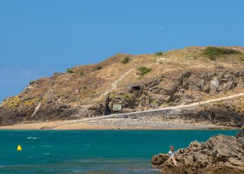 Sentier côtier breton longeant des falaises au-dessus d’une mer turquoise