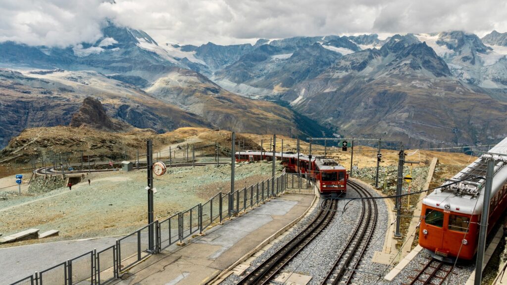 Train de montagne circulant dans un paysage alpin, avec des sentiers de randonnée en arrière-plan