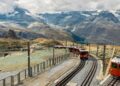 Train de montagne circulant dans un paysage alpin, avec des sentiers de randonnée en arrière-plan